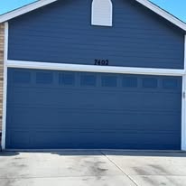 Two-car garage door and gable painted navy blue with white trim